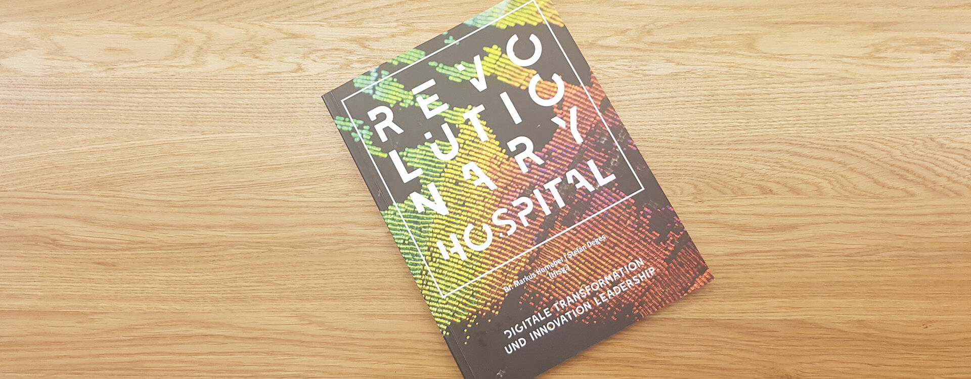 Agentur lege artis - Das Buch "Revolutionary Hospital" liegt auf einem Tisch